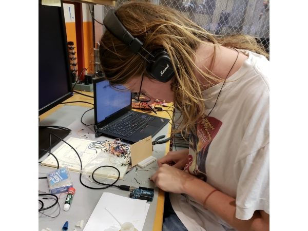 Student Wearing Headphones Working on Circuit