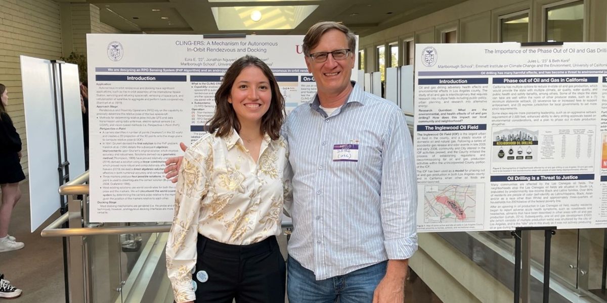 Two People Standing next to Each Other in front of Poster at Conference