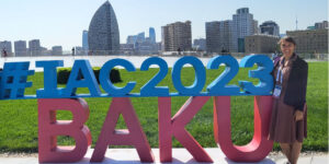 Person standing next to IAC2023 BAKU sign