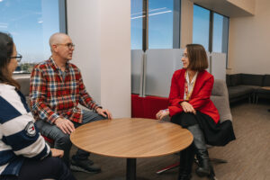 People seated around round coffee table chatting
