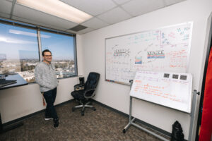 Researcher standing next to whiteboards with many annotations